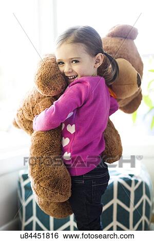 Portrait of girl (4-5) hugging teddy bear View Large Photo Image Stock Photograph - Portrait of girl (4-5) hugging teddy bear. Fotosearch