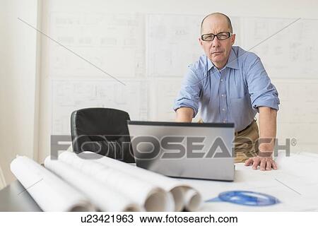 Portrait of mature architect using laptop in office View Large Photo Image Stock Image - Portrait of mature architect using laptop in office. Fotosearch