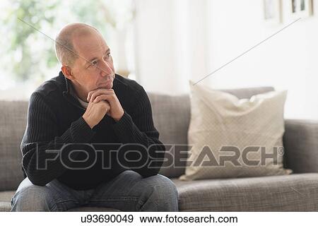 Portrait of mature man relaxing on sofa in living room View Large Photo Image Stock Photo - Portrait of mature man relaxing on sofa in living room . Fotosearch
