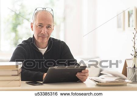 Portrait of mature man working in home office View Large Photo Image Stock Photograph - Portrait of mature man working in home office . Fotosearch