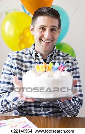 Portrait of mid-adult man with birthday cake View Large Photo Image Picture - Portrait of mid-adult man with birthday cake. Fotosearch