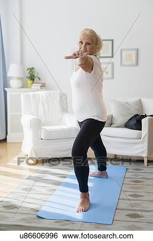 Stock Photograph - Portrait of senior woman doing yoga. Fotosearch