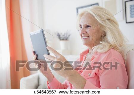 Portrait of senior woman using digital tablet View Large Photo Image Stock Photo - Portrait of senior woman using digital tablet. Fotosearch