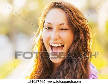 Stock Photography - Portrait of winking woman. Fotosearch
