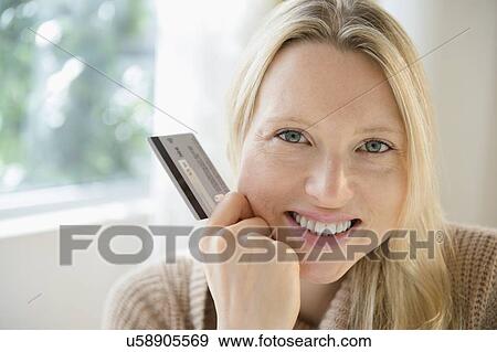 Stock Photo - Portrait of woman holding credit card. Fotosearch