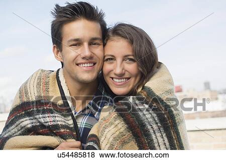 Portrait of young couple wrapped in blanket View Large Photo Image Stock Photo - Portrait of young couple wrapped in blanket. Fotosearch