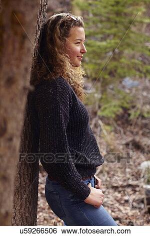Portrait of young woman leaning on tree View Large Photo Image Stock Photograph - Portrait of young woman leaning on tree. Fotosearch