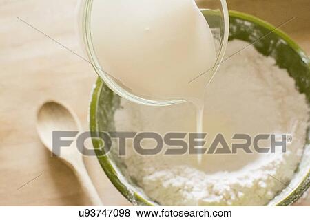 Pouring milk into bowl with flour View Large Photo Image Stock Photo - Pouring milk into bowl with flour. Fotosearch