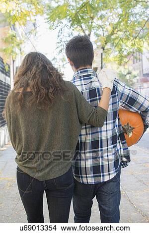 Rear view of young couple on sidewalk View Large Photo Image Picture - Rear view of young couple on sidewalk. Fotosearch