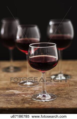 "Red wine in glasses on wooden table, studio shot" View Large Photo Image Stock Photography - "Red wine in glasses on wooden table, studio shot". Fotosearch