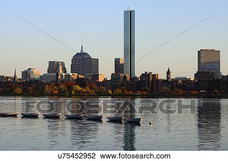 Stock Image - "Row of boats on river, waterfront in background". Fotosearch