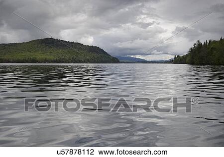 Scenic view of lake on cloudy day View Large Photo Image Stock Image - Scenic view of lake on cloudy day. Fotosearch