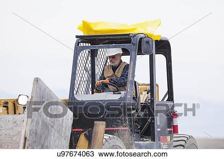 Stock Image - Senior man working on earthmover. Fotosearch