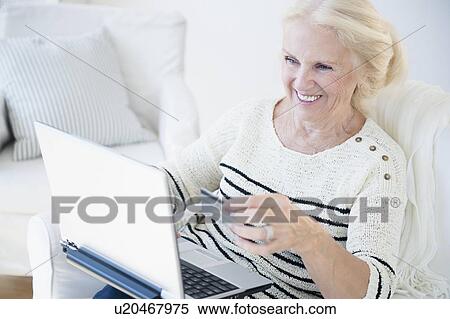 Senior woman doing on-line shopping View Large Photo Image Stock Photography - Senior woman doing on-line shopping. Fotosearch