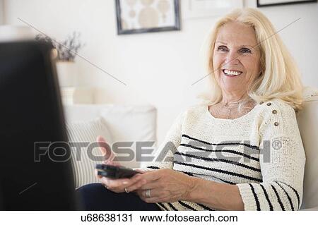 Senior woman holding remote control View Large Photo Image Stock Image - Senior woman holding remote control. Fotosearch