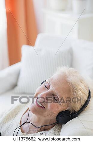 Stock Image - Senior woman listening to music. Fotosearch