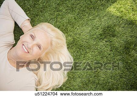 Senior woman lying on grass View Large Photo Image Picture - Senior woman lying on grass. Fotosearch