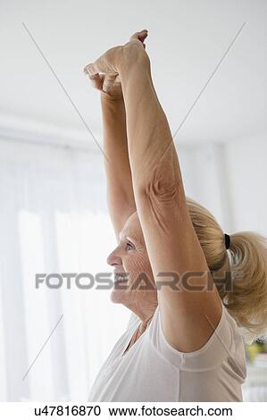 Stock Image - Senior woman with arms raised. Fotosearch