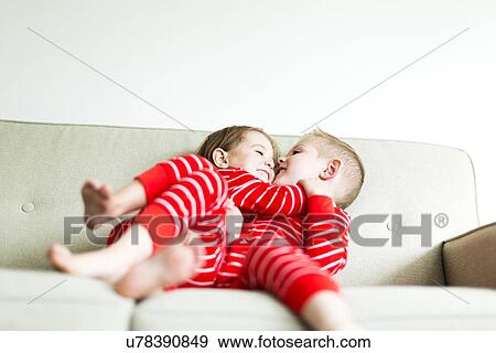 "Siblings (2-3, 4-5) in red pajamas playing on sofa" View Large Photo Image Stock Photo - "Siblings (2-3, 4-5) in red pajamas playing on sofa". Fotosearch