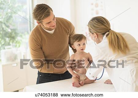 Small boy (2-3) with his father and female doctor in doctor's office View Large Photo Image Stock Photo - Small boy (2-3) with his father and female doctor in doctor's office. Fotosearch