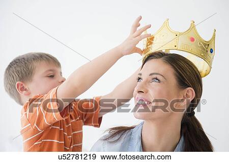 Son (6-7) putting crown to mother's head View Large Photo Image Stock Photo - Son (6-7) putting crown to mother's head. Fotosearch