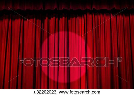 Stock Image - Spotlight on red curtain. Fotosearch