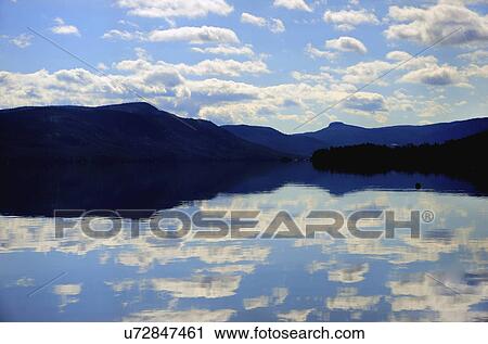 Symmetrical view of blue sky and clouds reflecting in lake View Large Photo Image Stock Image - Symmetrical view of blue sky and clouds reflecting in lake. Fotosearch