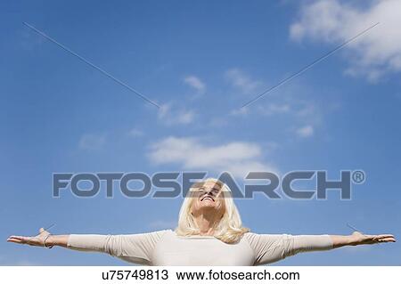 Upward view of senior woman with arms outstretched View Large Photo Image Stock Image - Upward view of senior woman with arms outstretched. Fotosearch