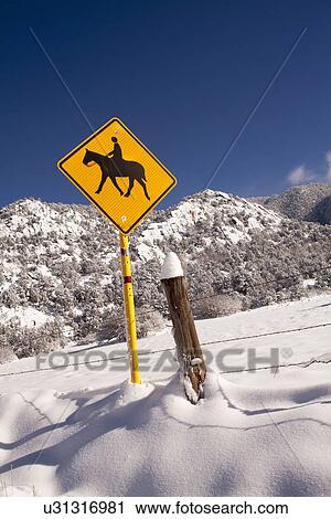 Stock Image - View of road sign and mountain in winter. Fotosearch
