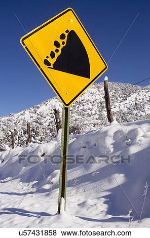 Stock Photo - View of road sign and snowcapped mountain. Fotosearch