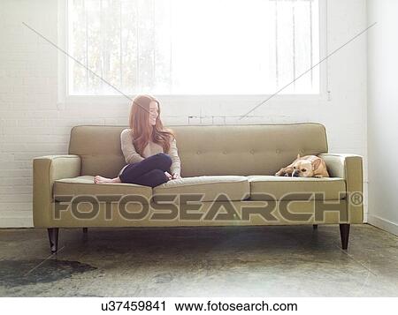 Stock Image - Woman and pug on sofa. Fotosearch