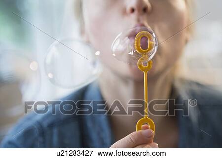 Stock Photo - Woman blowing bubbles. Fotosearch