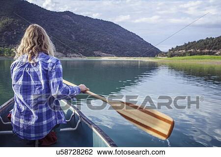 Stock Image - Woman canoeing in lake. Fotosearch