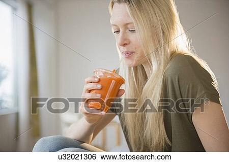 Woman drinking carrot juice View Large Photo Image Stock Photograph - Woman drinking carrot juice. Fotosearch
