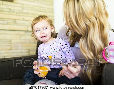 Stock Photo - Woman feeding her daughter (12-17 months). Fotosearch