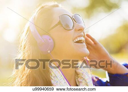 Woman in sunglasses and headphones outdoors View Large Photo Image Stock Photo - Woman in sunglasses and headphones outdoors. Fotosearch