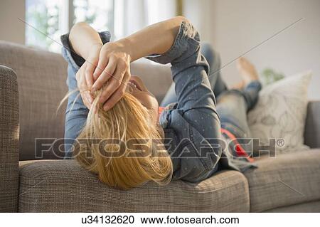 Woman lying on sofa View Large Photo Image Stock Image - Woman lying on sofa. Fotosearch