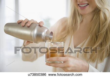 Woman pouring cocktail into glass View Large Photo Image Stock Photograph - Woman pouring cocktail into glass. Fotosearch
