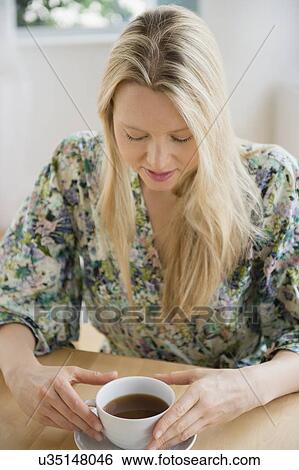 Stock Photograph - Woman sitting with cup of coffee. Fotosearch