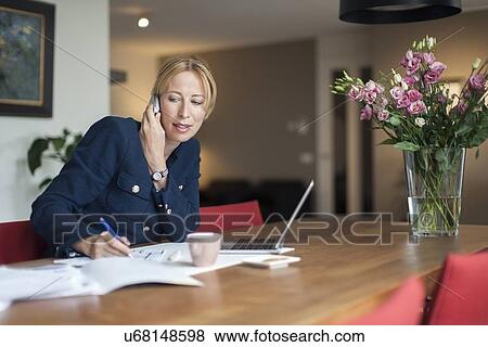 Woman talking on phone and making notes View Large Photo Image Stock Photo - Woman talking on phone and making notes. Fotosearch