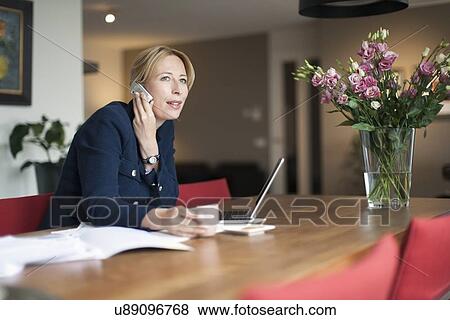 Stock Photo - Woman talking on phone and making notes. Fotosearch