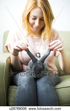 Woman touching rabbit's ears View Large Photo Image Stock Photograph - Woman touching rabbit's ears. Fotosearch