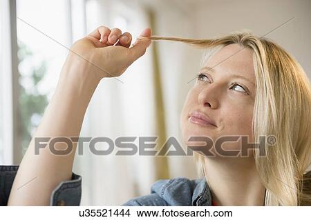 Woman twisting her hair View Large Photo Image Picture - Woman twisting her hair. Fotosearch