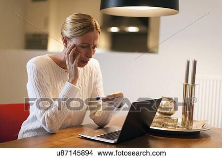 Woman using laptop and looking at pregnancy test View Large Photo Image Picture - Woman using laptop and looking at pregnancy test. Fotosearch