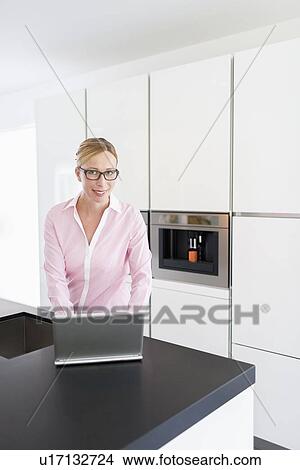 Picture - Woman using on laptop at home. Fotosearch