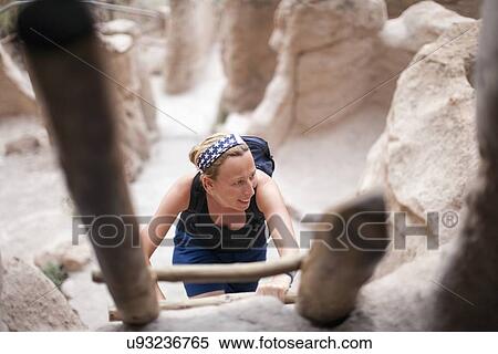 Stock Photography - Woman walking up ladder. Fotosearch