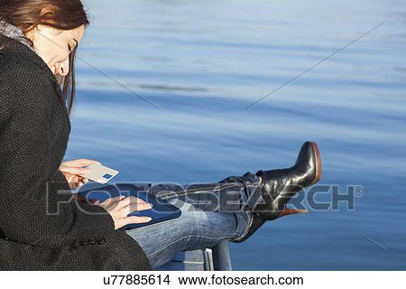 Picture - Woman with tablet by lake. Fotosearch