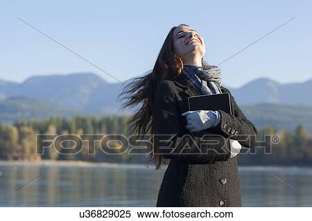 Stock Photography - Woman with tablet by lake. Fotosearch