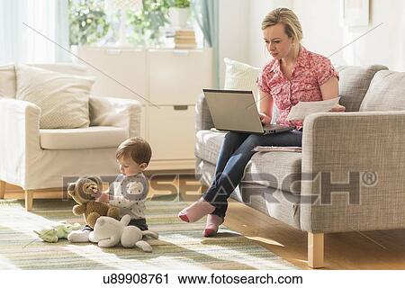Working mother and son (2-3 years) in living room View Large Photo Image Stock Image - Working mother and son (2-3 years) in living room. Fotosearch