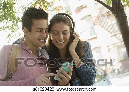 Young couple listening to music View Large Photo Image Stock Photo - Young couple listening to music. Fotosearch